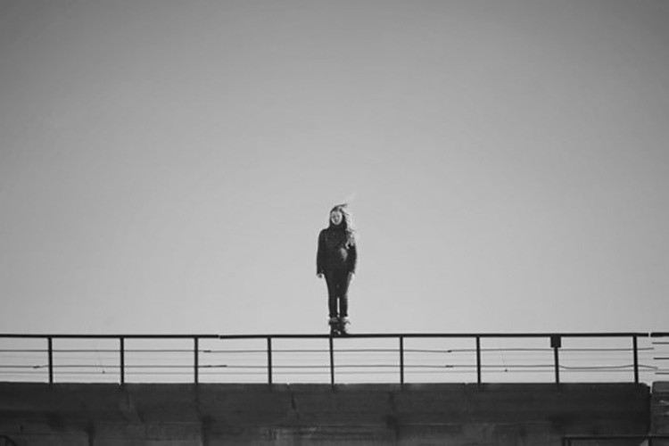 Парень стоит на мосту