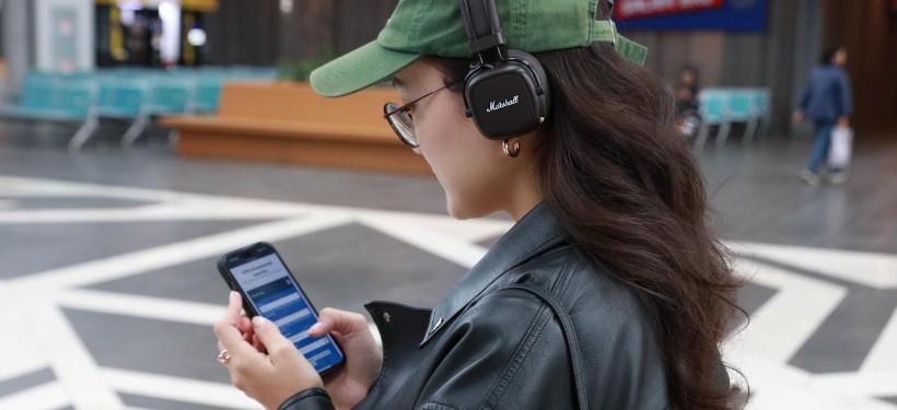 девушка на вокзале с телефоном в руке