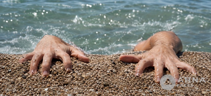 человек выбирается из воды